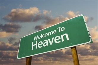 Welcome to heaven green road sign with dramatic clouds and sky
