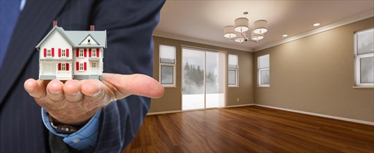 Real estate agent holding model home in new room of house