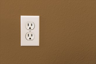 Electrical sockets in colorful brown wall of house