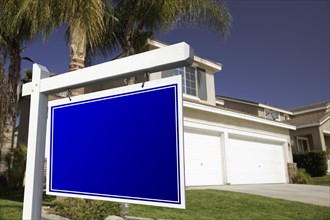 Blank real estate sign in front of house