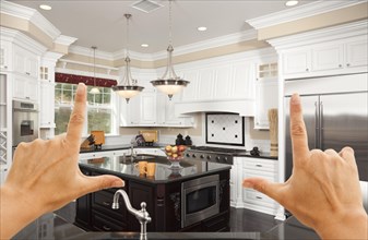 Female hands framing A beautiful custom kitchen interior