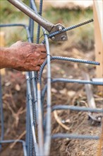 Worker using tools to bend steel rebar at construction site