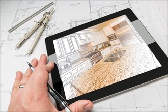 Hand of architect on computer tablet showing custom kitchen illustration photo combination over house plans