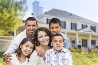 Happy hispanic family portrait in front of beautiful house