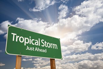 Tropical storm green road sign with dramatic clouds and sky