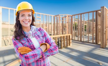 Young attractive female construction worker wearing gloves