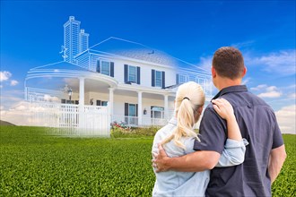 Couple facing ghosted house drawing and photo over green landscape