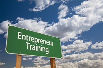 Entrepreneur training green road sign and dramatic clouds background