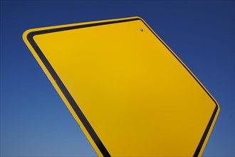 Blank yellow road sign against a dramatic blue sky with clipping path