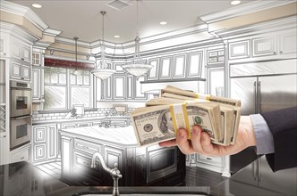 Hand holding stacks of money over custom kitchen design drawing and photo combination