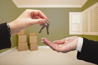 Woman handing over the house keys to A new home inside empty green colored room