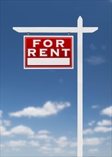 Left facing for rent real estate sign on a blue sky with clouds
