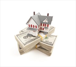Small house on stacks of hundred dollar bills isolated on a white background