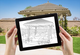 Female hands holding computer tablet with drawing of pergola on screen