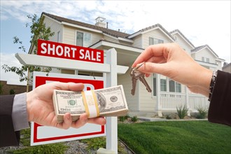 Handing over cash for house keys and short sale real estate sign in front of home