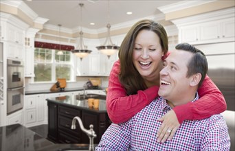 Happy laughing affectionate couple in beautiful new kitchen