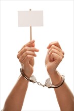 Handcuffed woman holding blank white sign isolated on a white background