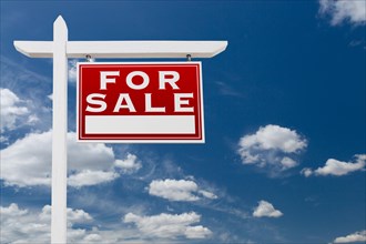 Right facing for sale real estate sign over blue sky and clouds with room for your text