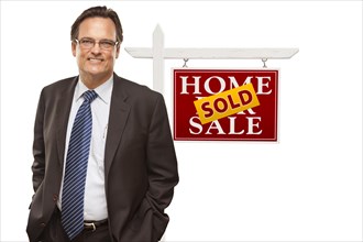 Businessman in front of sold home for sale real estate sign isolated on a white background