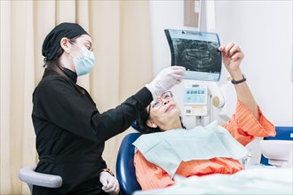 Dentist showing x-ray to patient