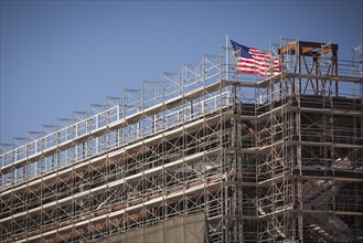 Majestic american flag flying on top of new building construction