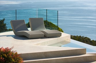 Custom luxury pool and chairs abstract overlooking the ocean