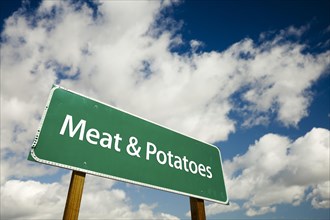 Meat and potatoes road sign with dramatic clouds and sky