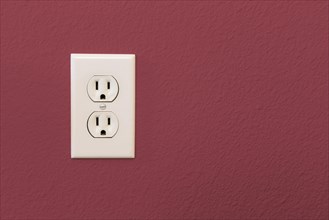 Electrical sockets in colorful burgundy wall of house