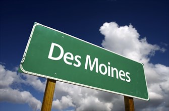 Des moines road sign with dramatic blue sky and clouds