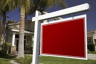 Blank real estate sign in front of house