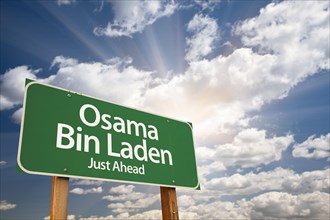 Osama bin laden green road sign on dramatic blue sky with clouds