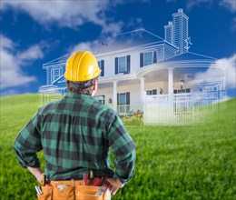 Contractor standing outdoors looking over grass site with ghosted house