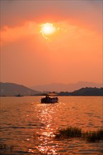 Tourist boat in lake Pichola on sunset. Udaipur