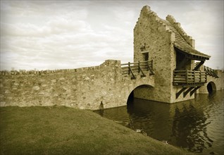Colorized ancient medieval replica bridge over river water
