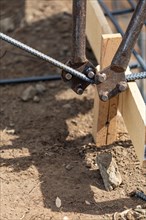Worker using tools to bend steel rebar at construction site