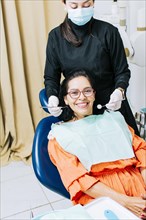 Dentist examining mouth to smiling patient