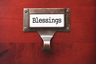 Lustrous wooden cabinet with blessings file label in dramatic light