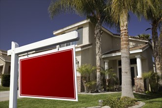 Blank real estate sign in front of house