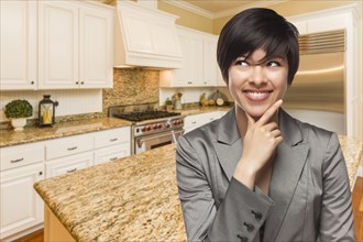 Pretty mixed-race woman looking back over shoulder inside custom kitchen interior