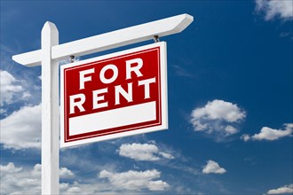 Right facing for rent real estate sign over blue sky and clouds with room for your text