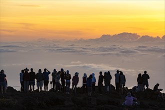 Touristen beobachten den Sonnenuntergang auf dem Gipfel des Haleakala Vulkan