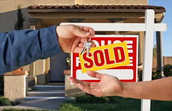 Handing over the keys to A new home with sold home for sale sign
