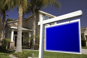 Blank real estate sign in front of house