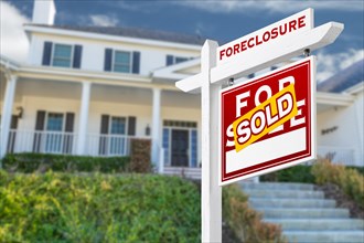 Right facing foreclosure sold for sale real estate sign in front of house