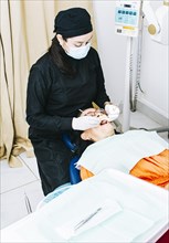 Dentist with patient lying down