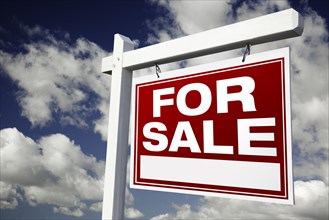 For sale real estate sign on clouds & sky background