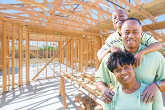 Young african american family on site inside their new home construction framing