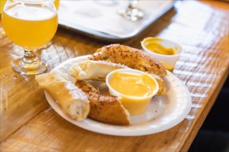 Abstract of small glass of micro brew beers and warm pretzels on bar