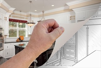 Male hand turning page of custom kitchen photograph to drawing underneath