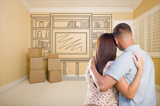 Hugging military couple in empty room with shelf design drawing on wall
